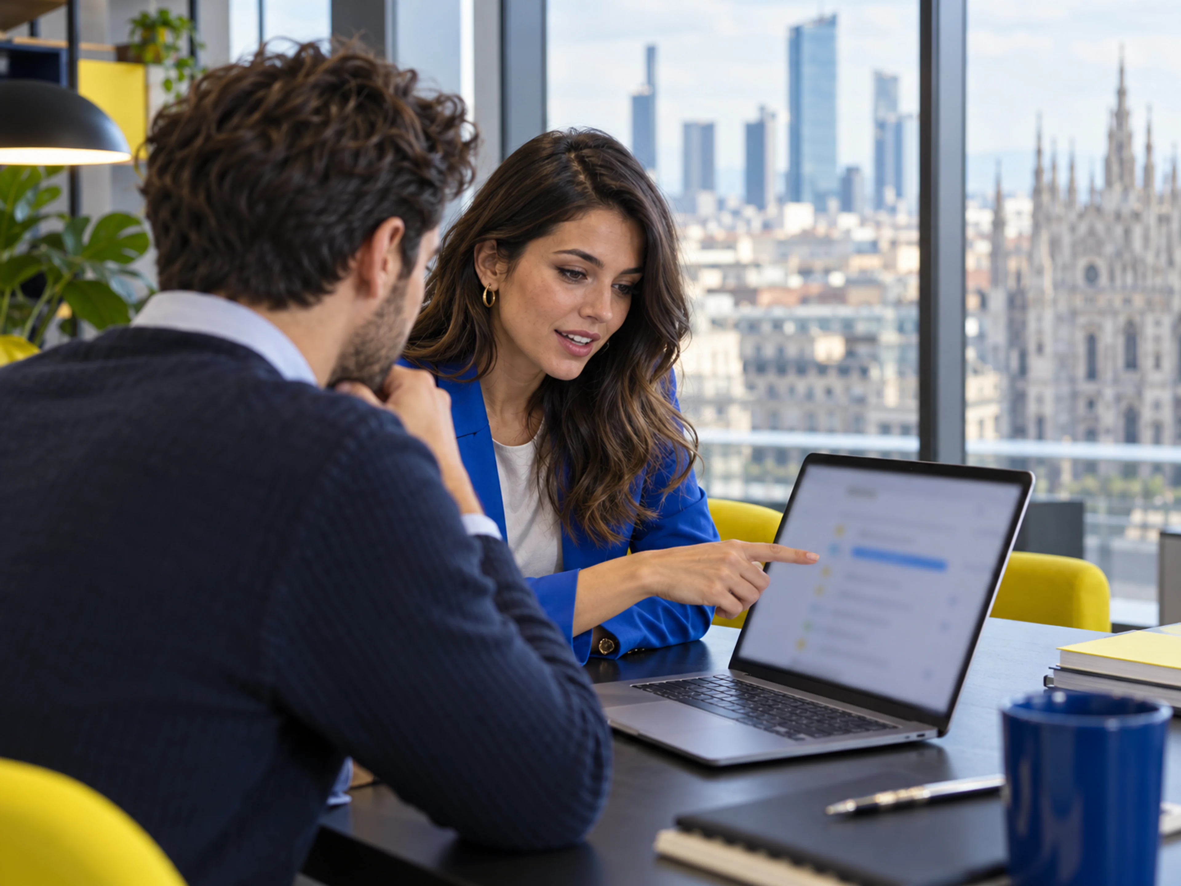 Una recruiter e un candidato esaminano insieme un annuncio sul laptop.